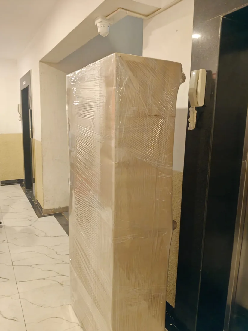 Tall household appliance covered in protective packing, supplied company photograph